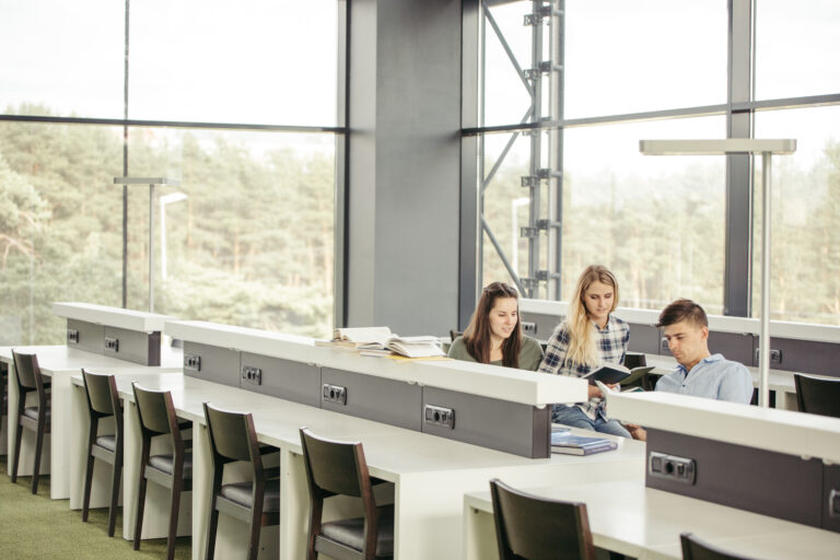Studenci uczący się razem w bibliotece uczelnianej